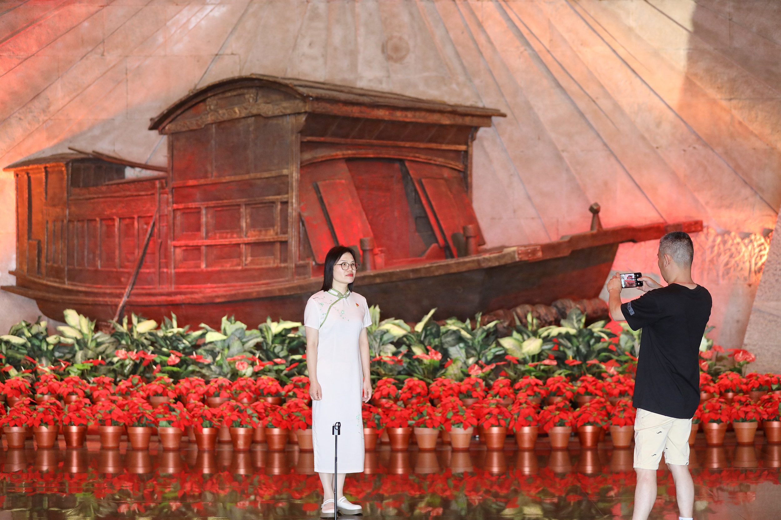 2025年6月24日，浙江嘉興，游客在南湖革命紀念館與紅船雕塑合影。（圖片來源：視覺中國）